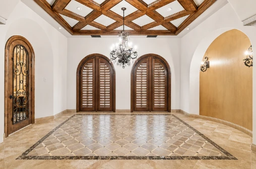 Unfurnished formal dining room with coffered ceiling and chandelier
