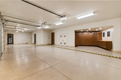 Unfurnished five-car garage with storage cabinetry