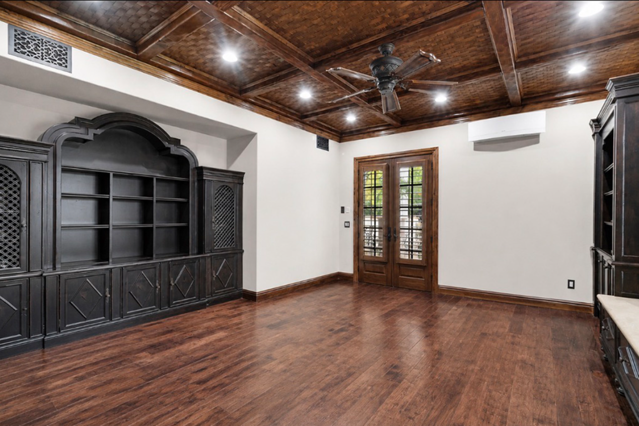 Office with wood built-ins, coffered ceiling, and wood floors